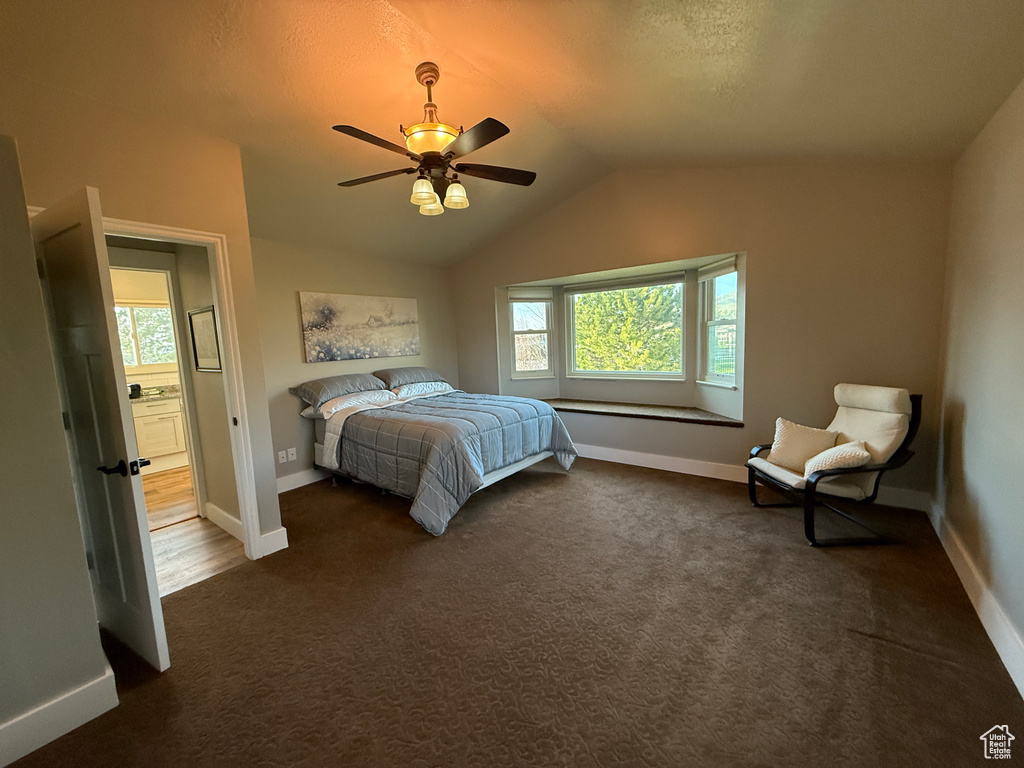 Bedroom featuring baseboards, dark carpet, lofted ceiling, and ceiling fan