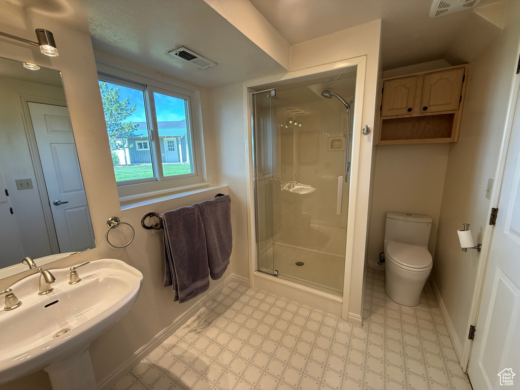 Full bathroom with tile patterned floors, a sink, a shower stall, toilet, and baseboards