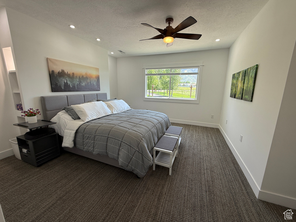 Bedroom with dark carpet, a textured ceiling, baseboards, recessed lighting, and ceiling fan