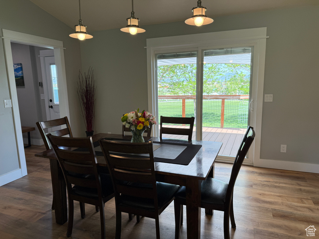 Dining area with wood finished floors, vaulted ceiling, and baseboards