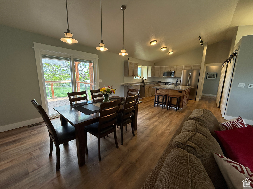 Dining space featuring lofted ceiling, wood finished floors, and baseboards