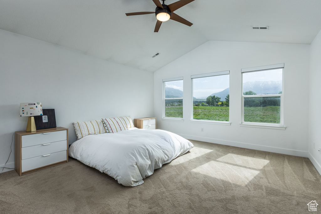 Carpeted bedroom featuring vaulted ceiling, baseboards, and ceiling fan