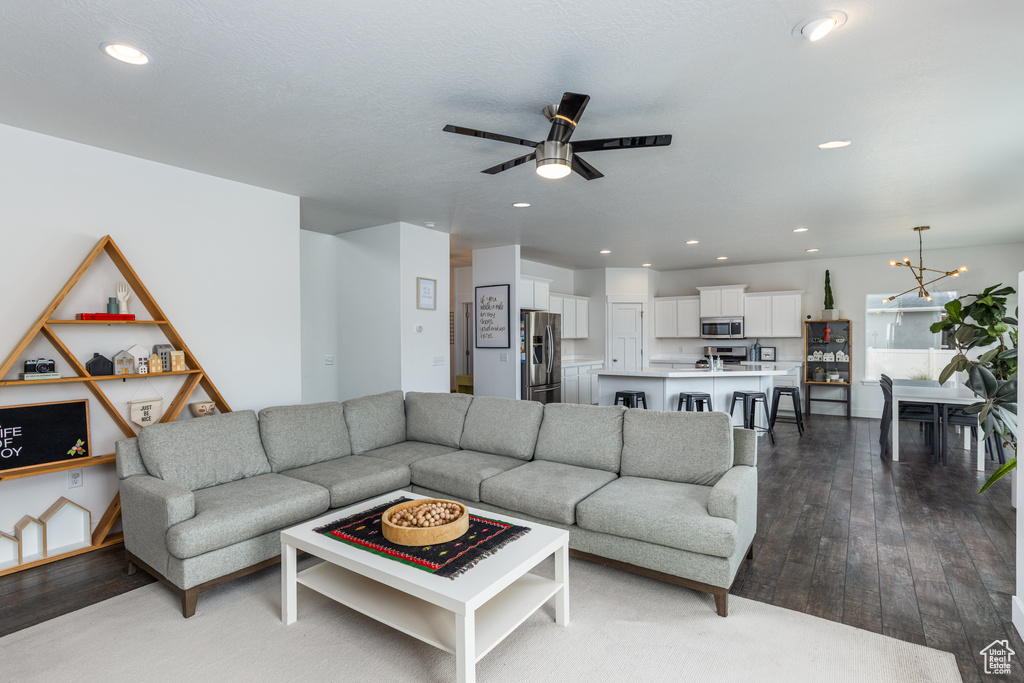 Living area featuring a ceiling fan, hardwood / wood-style flooring, recessed lighting, and a chandelier