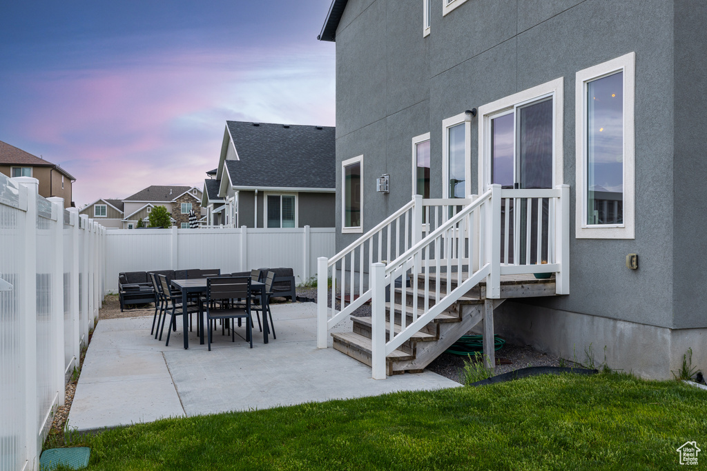 Patio terrace at dusk with a fenced backyard