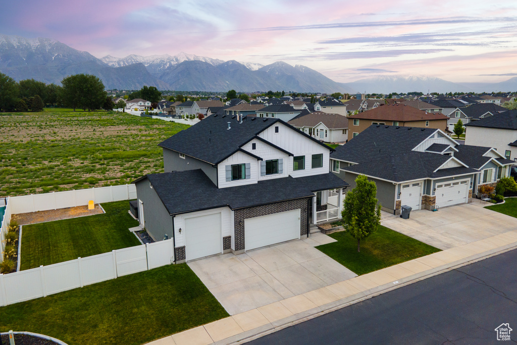 View of front of house with concrete driveway, a residential view, a mountain view, and a shingled roof