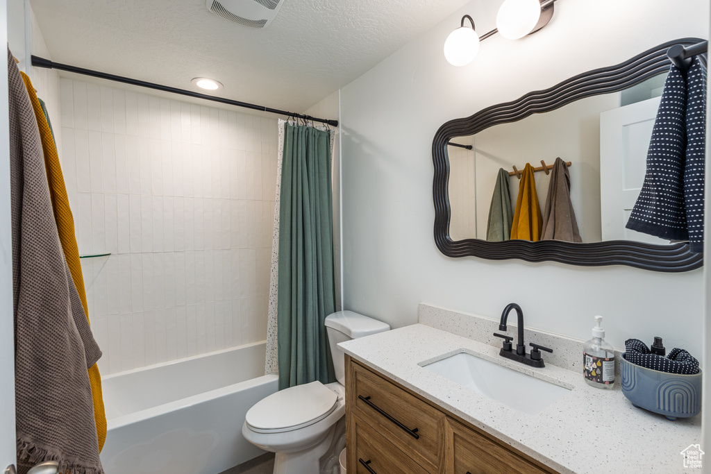 Bathroom featuring toilet, vanity, shower / bathtub combination with curtain, and recessed lighting