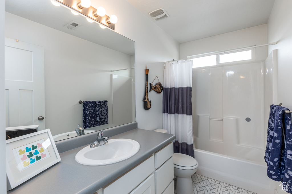 Full bathroom with tile patterned floors, vanity, toilet, and shower / tub combo