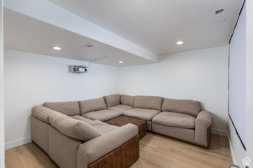 Living room with light wood-style flooring, baseboards, and recessed lighting