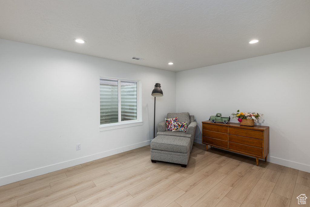 Living area featuring light wood-style floors, baseboards, and recessed lighting