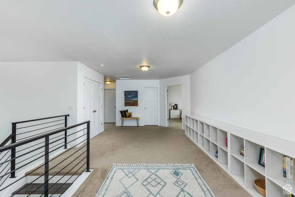 Hallway with an upstairs landing and carpet