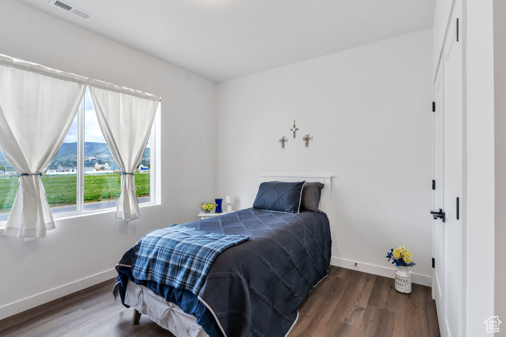 Bedroom with baseboards, wood finished floors, and a mountain view