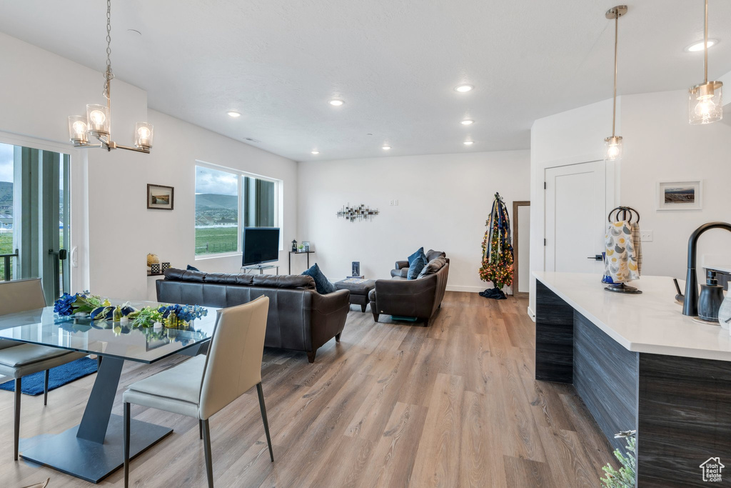 Dining room with light wood-style flooring, recessed lighting, a chandelier, and baseboards