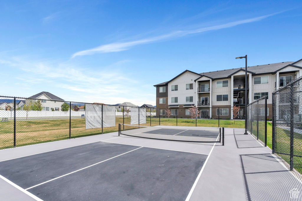 View of basketball court featuring a tennis court, fence, and community basketball court