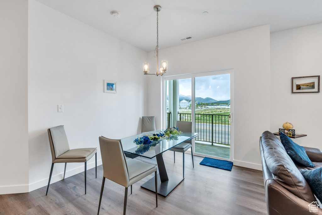 Dining room featuring a chandelier, wood finished floors, baseboards, and a mountain view