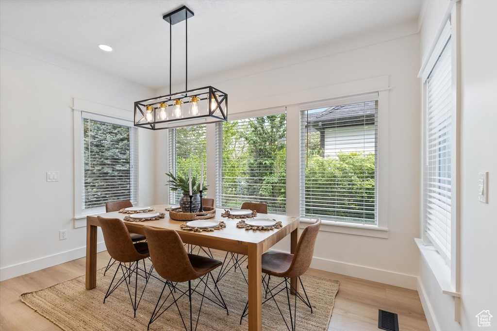 Dining area with healthy amount of natural light, light wood-style floors, baseboards, and recessed lighting