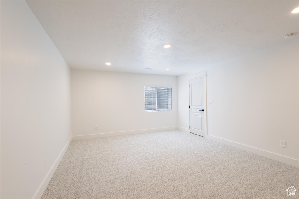 Unfurnished room featuring light colored carpet, recessed lighting, baseboards, and a smoke detector