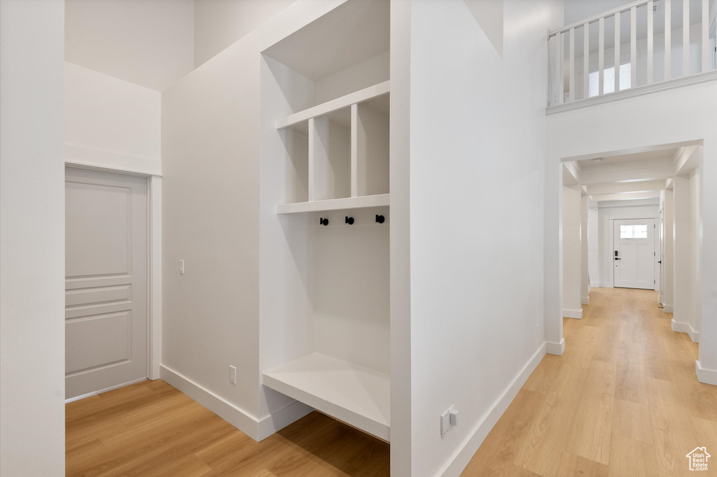 Mudroom featuring light wood-style flooring and baseboards