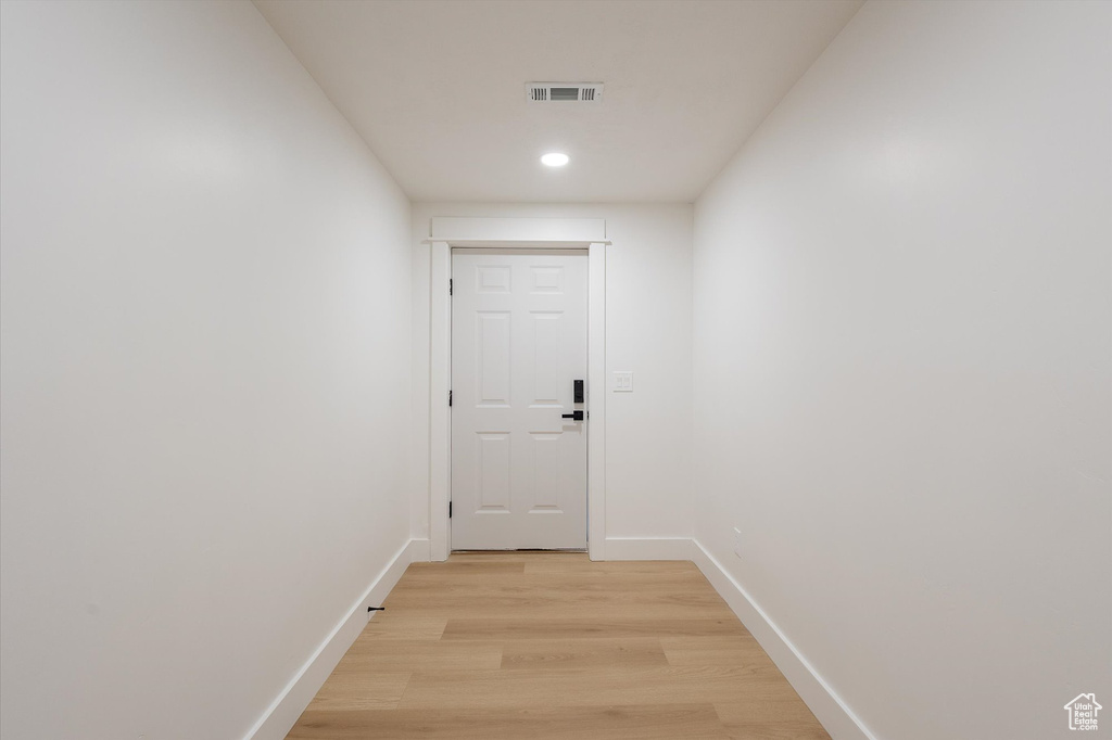 Hall with light wood-style flooring, baseboards, and recessed lighting