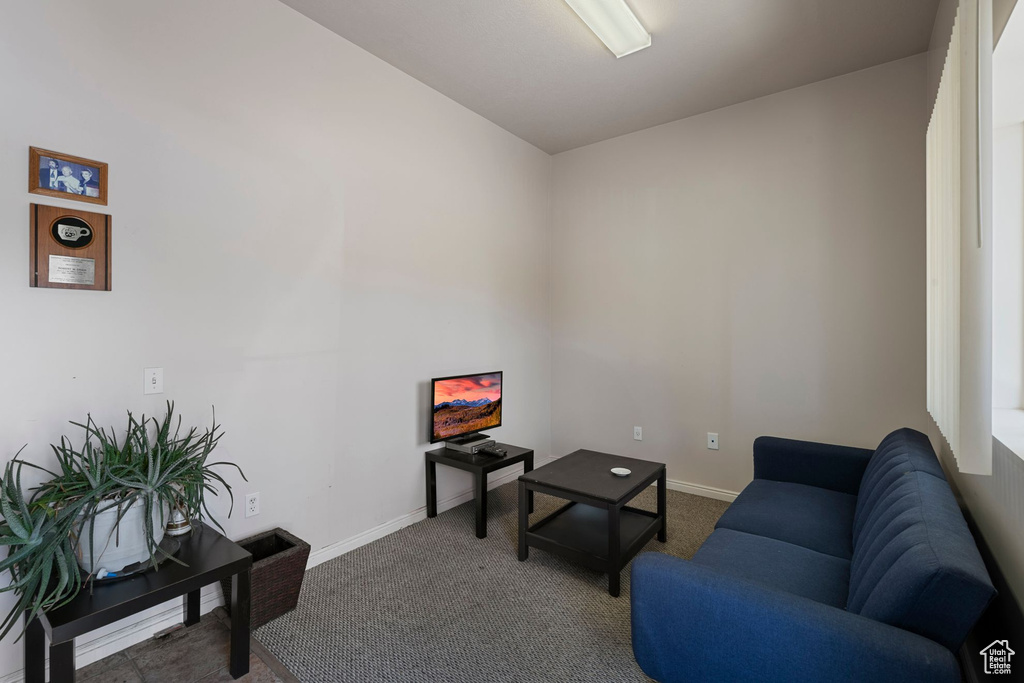 Carpeted living area featuring baseboards