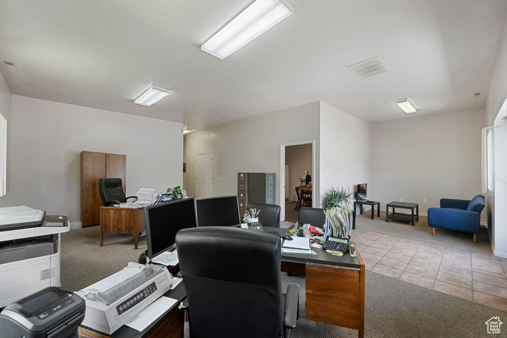 Carpeted office space featuring baseboards and tile patterned flooring
