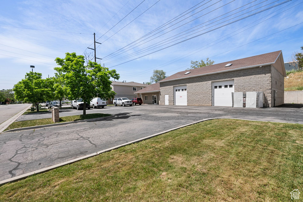 View of front of house featuring a front yard, brick siding, a garage, and roof with shingles