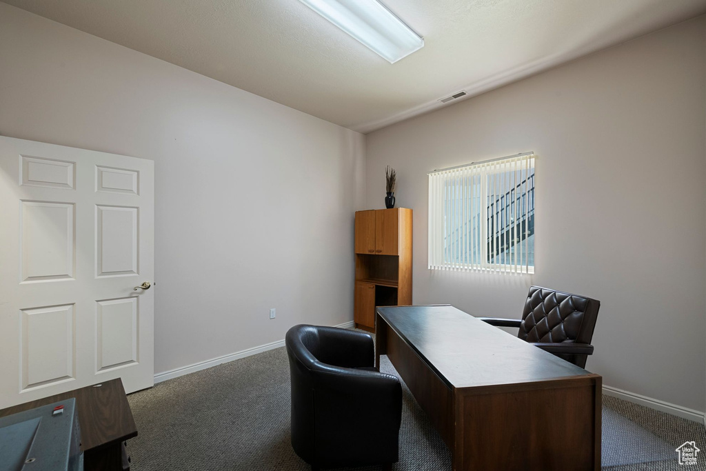 Carpeted office space with baseboards