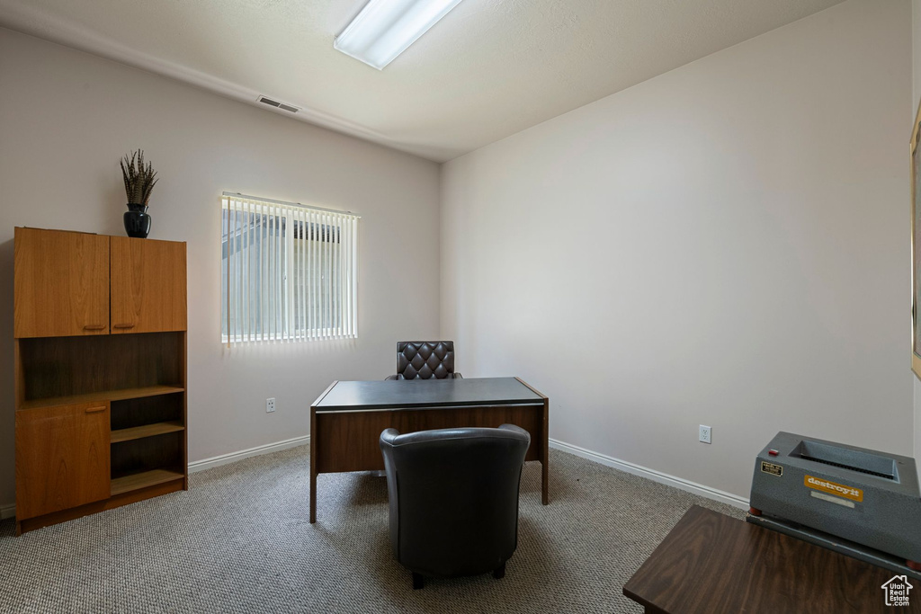 Carpeted office space with baseboards