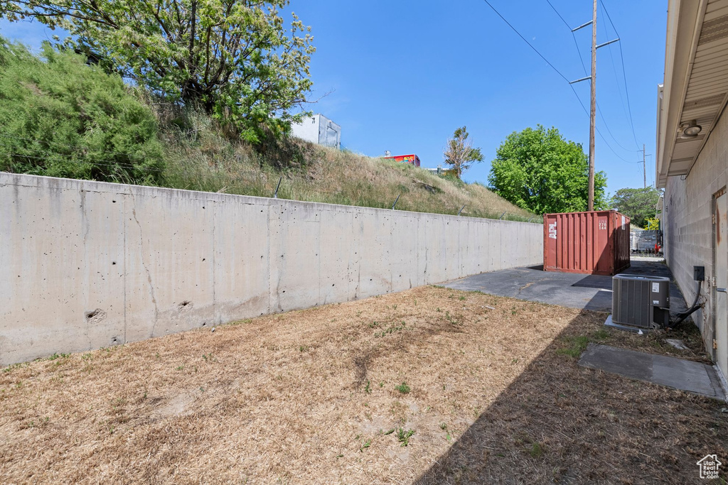 Fenced backyard featuring cooling unit and a patio