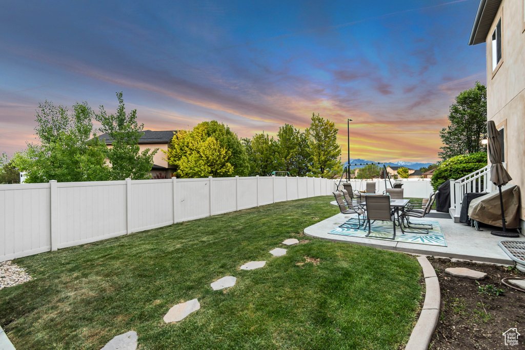 Yard at dusk featuring a patio