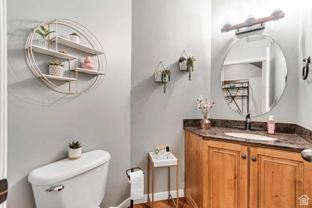 Bathroom with wood finished floors, toilet, and vanity