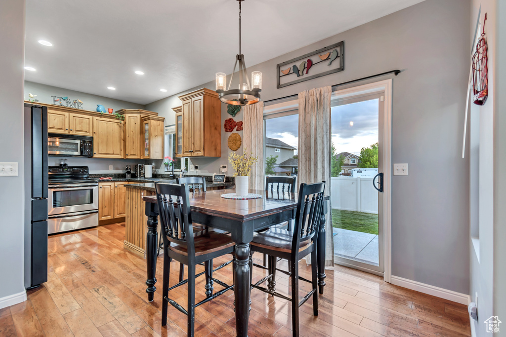 Dining room featuring light wood-style flooring, baseboards, recessed lighting, and a chandelier