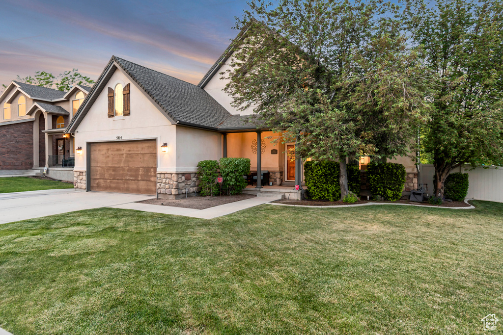 View of front of property featuring stone siding, an attached garage, concrete driveway, stucco siding, and a shingled roof