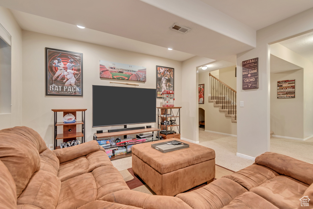 Living room featuring stairs, light colored carpet, baseboards, and recessed lighting