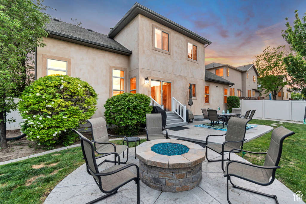 Patio terrace at dusk featuring an outdoor fire pit and entry steps