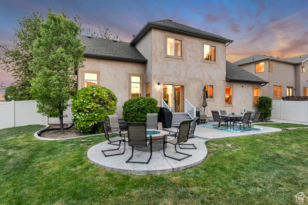 Back of property with a patio, stucco siding, and roof with shingles