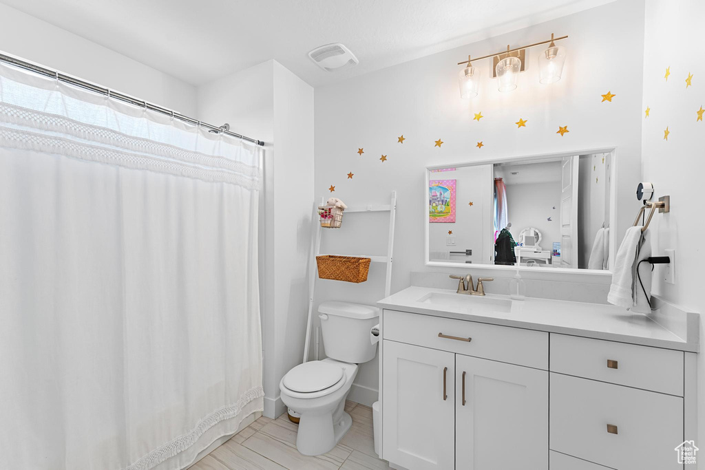 Full bath featuring toilet, vanity, and tile patterned floors