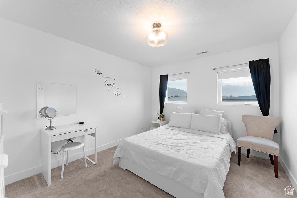 Bedroom featuring light colored carpet and baseboards