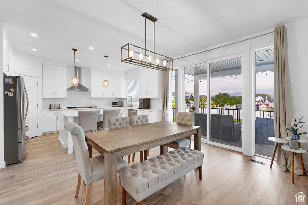 Dining room featuring light wood-style flooring, a chandelier, and recessed lighting