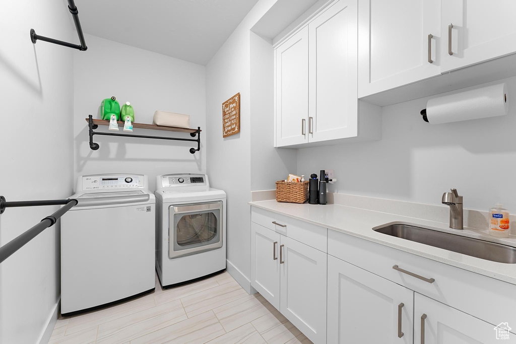 Laundry room with washing machine and dryer, cabinet space, and baseboards