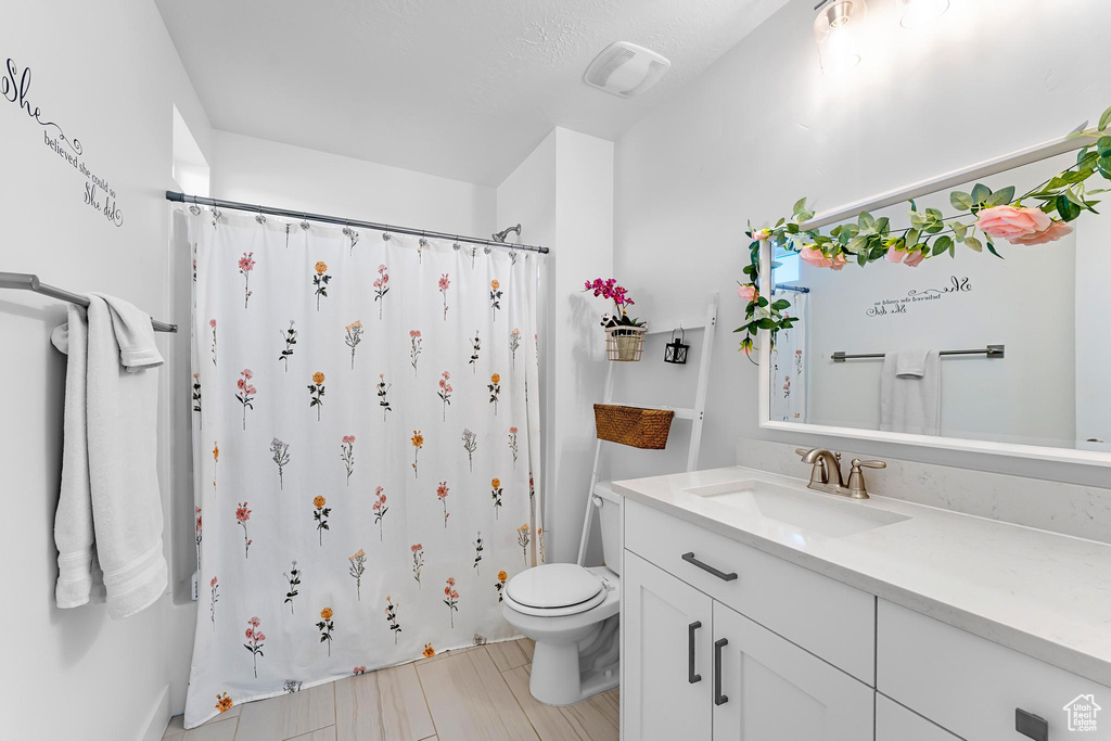 Full bath featuring toilet, vanity, and a shower with curtain