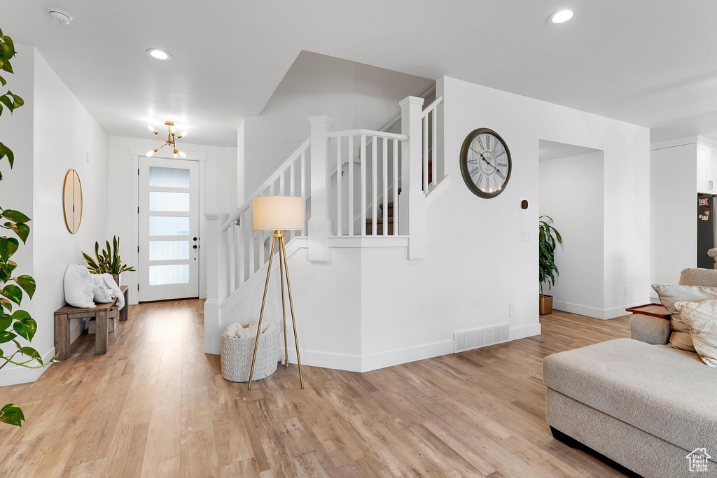 Foyer entrance with stairs, light wood-style floors, baseboards, a chandelier, and recessed lighting