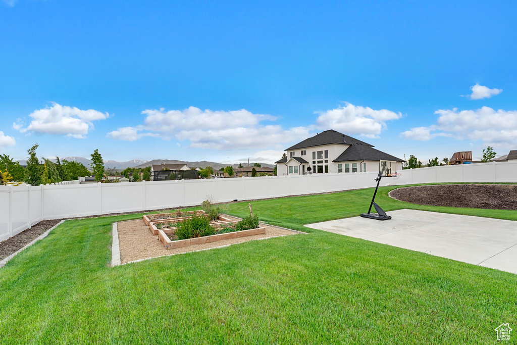 View of yard featuring a vegetable garden, a patio area, and a mountain view