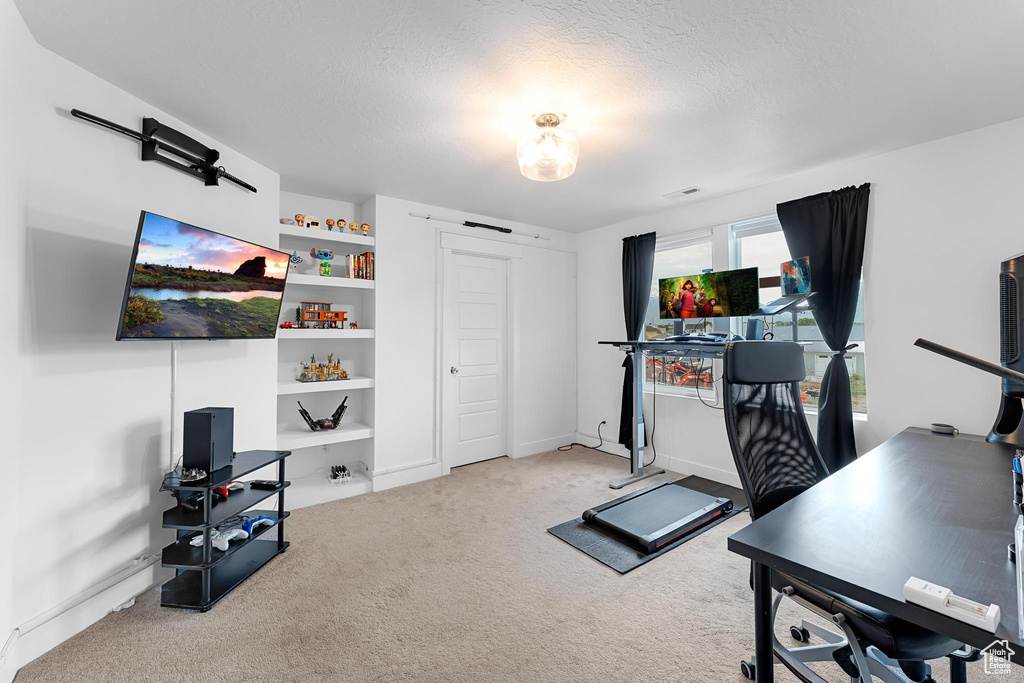 Exercise area featuring carpet floors and a textured ceiling