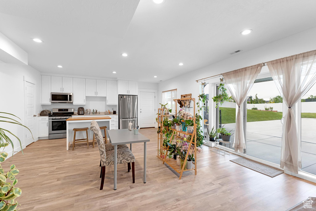 Dining area featuring light wood finished floors and recessed lighting