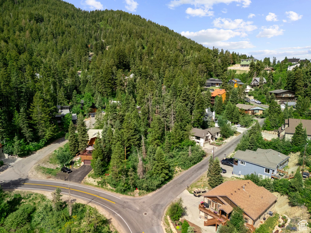 Aerial view of property and surrounding area with a forest and nearby suburban area
