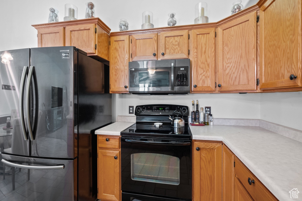 Kitchen with appliances with stainless steel finishes, light countertops, and brown cabinets