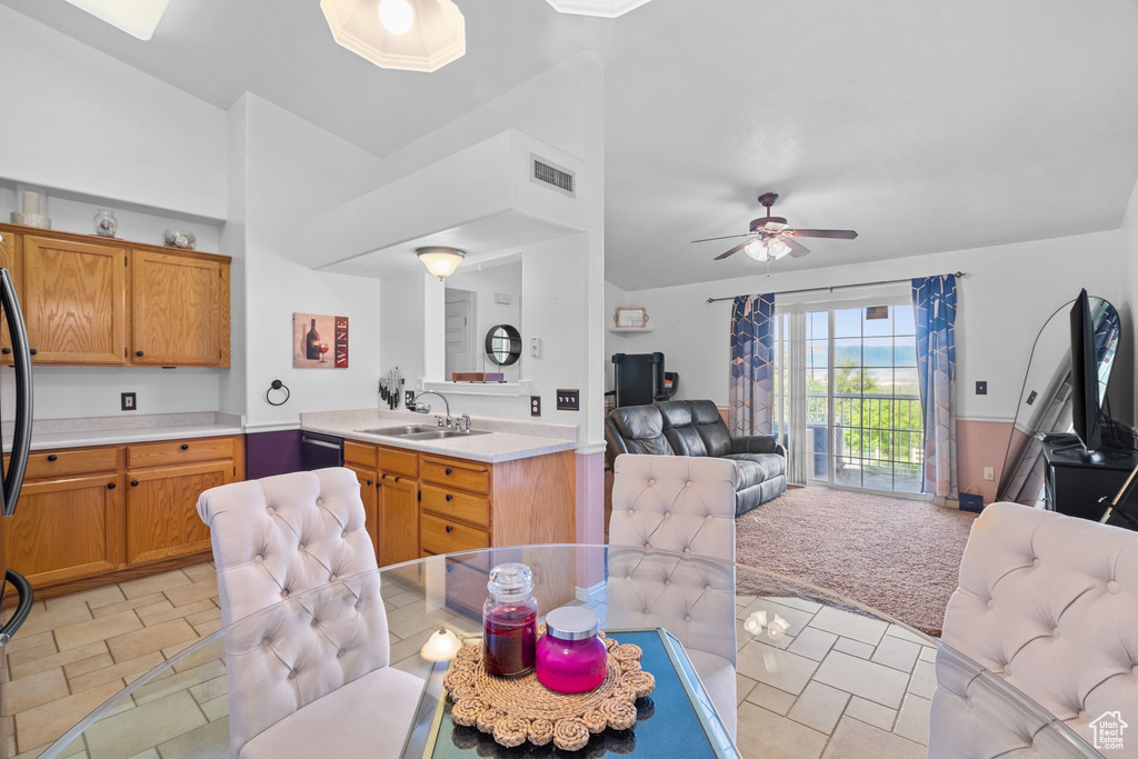 Kitchen featuring open floor plan, a sink, dishwasher, and light countertops