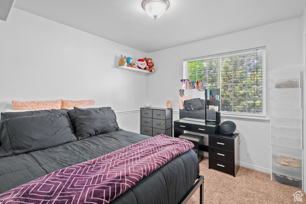 Bedroom with light colored carpet and baseboards