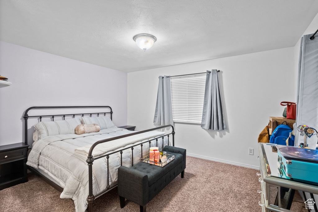Bedroom featuring carpet and baseboards