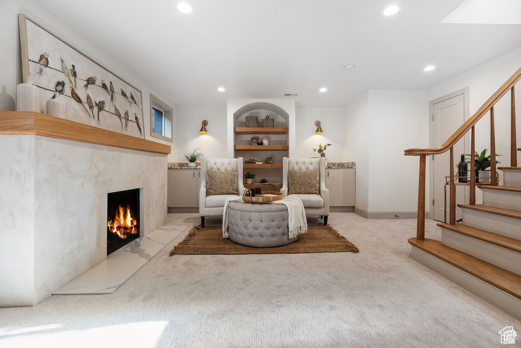 Sitting room featuring recessed lighting, stairs, a premium fireplace, carpet flooring, and built in features